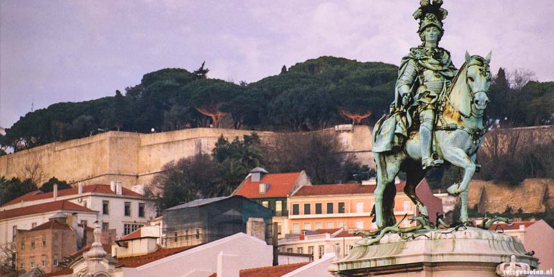 De grote muren van het Castelo de Sao Jorge steken hoog boven de stad uit