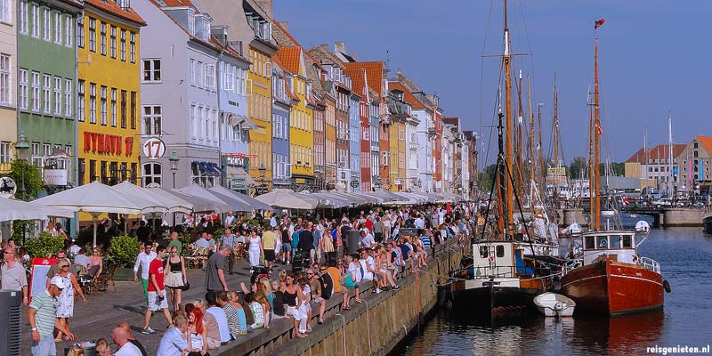 De gezellige Nyhavn in Kopenhagen. Langs het water van de haven zijn volop terrasjes en restaurantjes te vinden