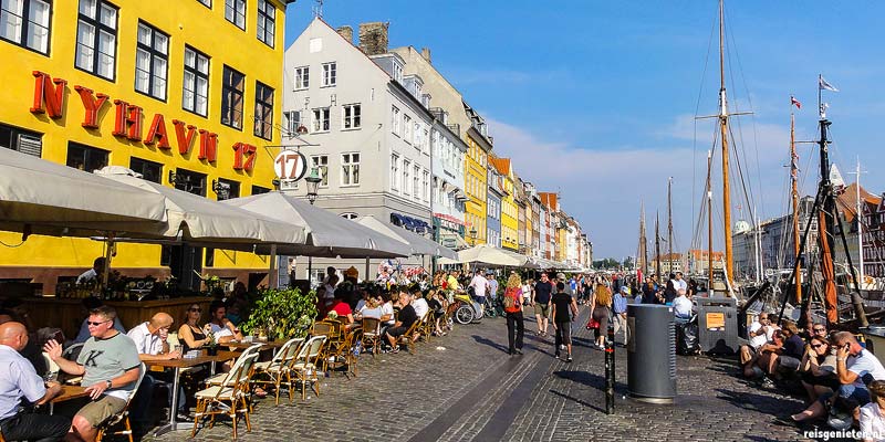 De gezellige Nyhavn in Kopenhagen. Langs het water van de haven zijn volop terrasjes en restaurantjes te vinden