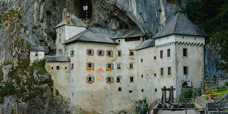 Het spectaculaire roofridderkasteel van Predjama in Slovenië ligt onder een overhangende rots geplak