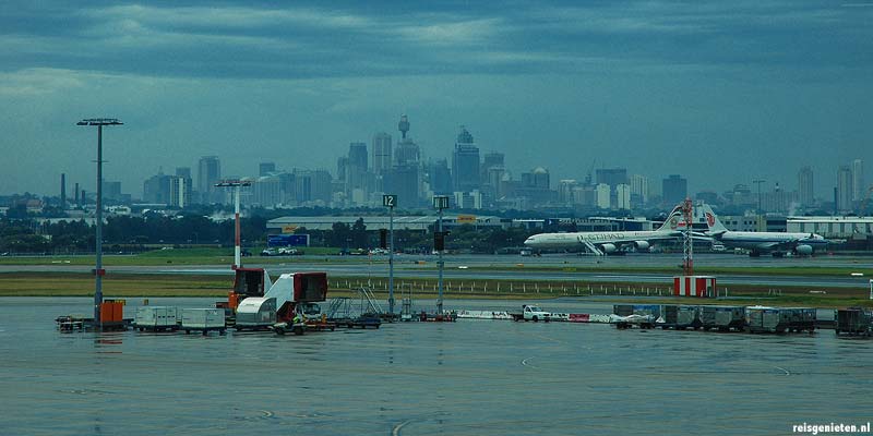 Het vliegveld van Sydney met op de achtergrond de skyline van de stad
